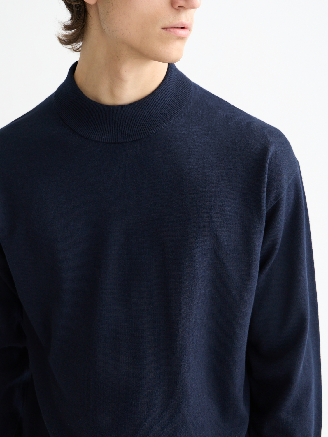 Cream knit mock neck sweater by Scotch & Soda featuring a close-up view of the soft, ribbed collar and textured knit fabric.