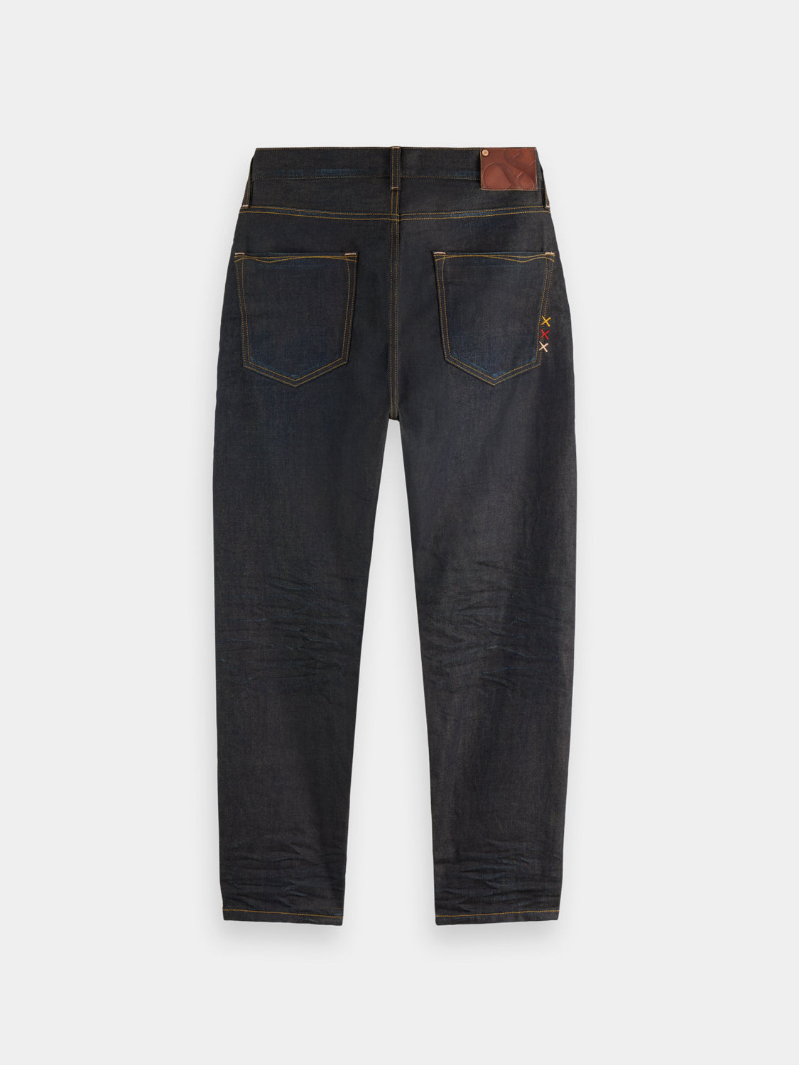 Dark blue Dean tapered denim jeans by Scotch & Soda, showing fitted cut and classic five-pocket design.
