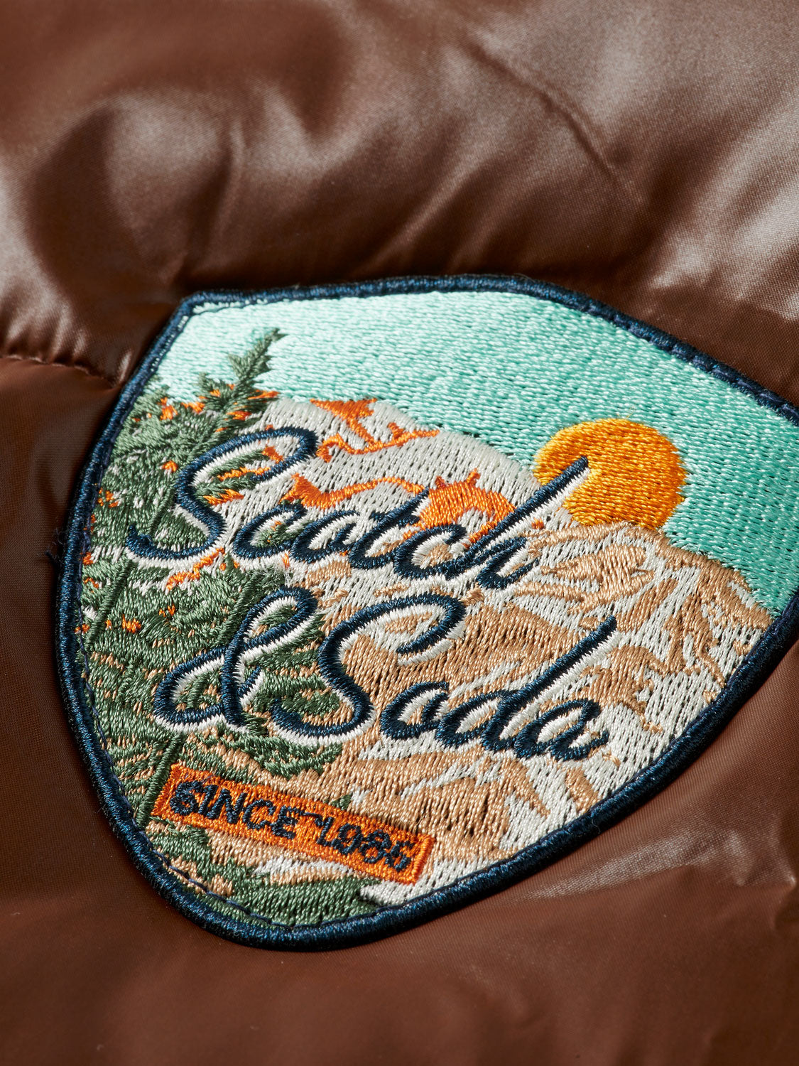 Scarlet lacquer puffer jacket by Scotch & Soda, featuring a shiny finish and quilted design, displayed on a hanger.