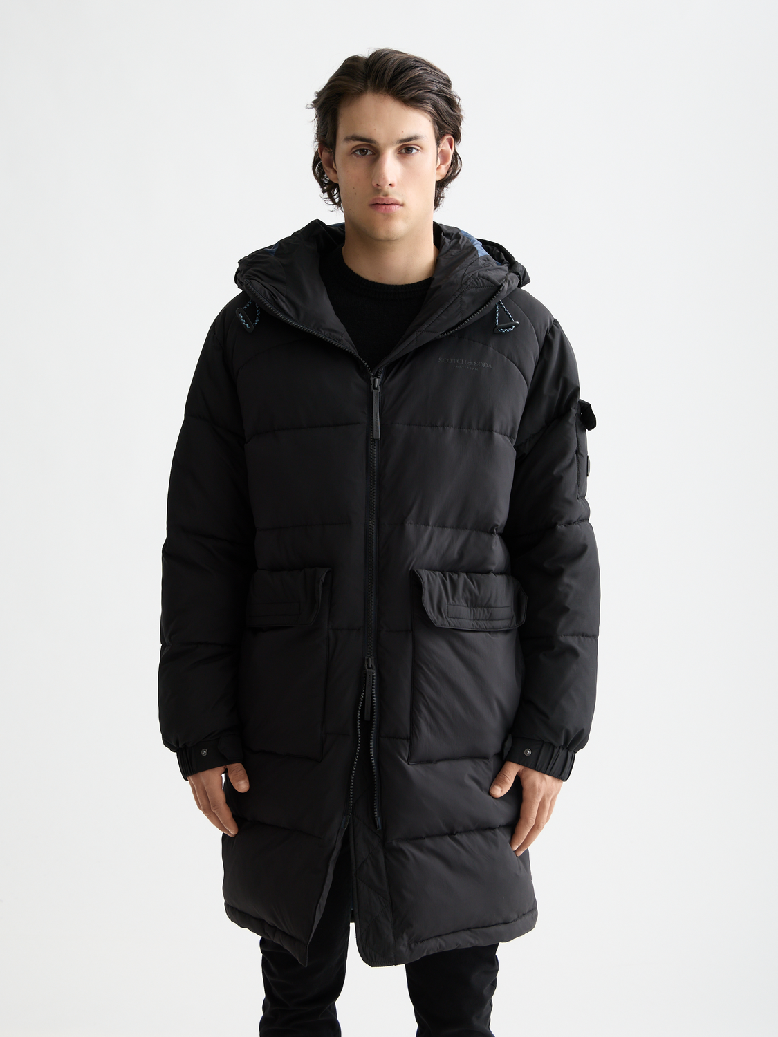 Long puffer jacket by Scotch & Soda, featuring a quilted design, high collar, and sleek silhouette for cold weather wear.