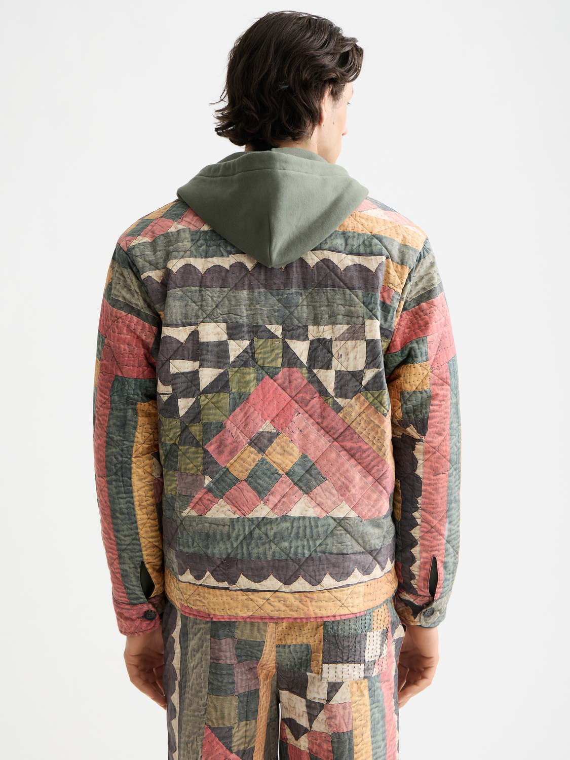 Scotch & Soda patchwork overshirt jacket with mixed fabric designs and button closure, displayed on a hanger.