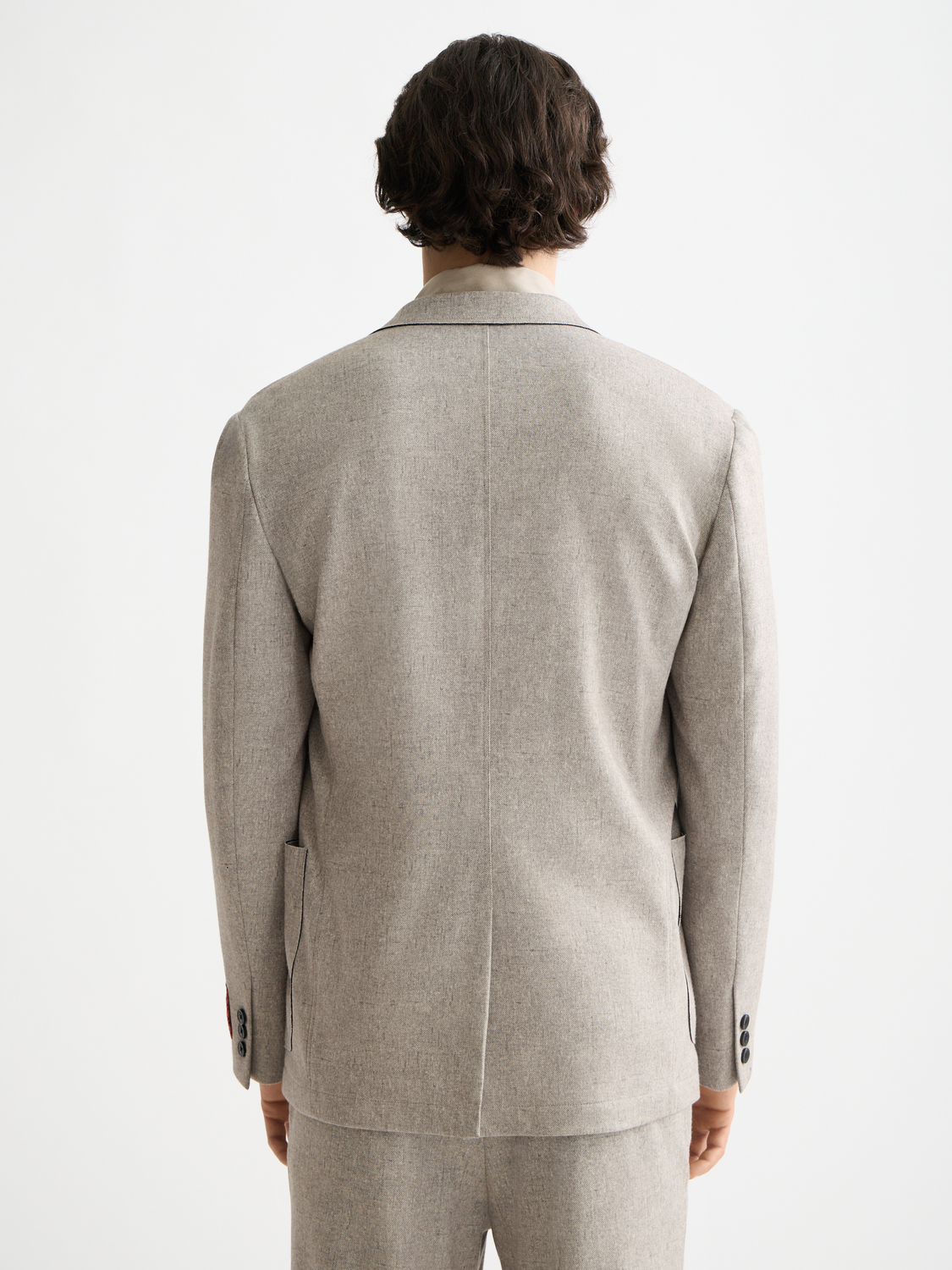 Unconstructed Scotch & Soda blazer with a tailored fit, featuring a classic lapel and patch pockets, shown from the back.