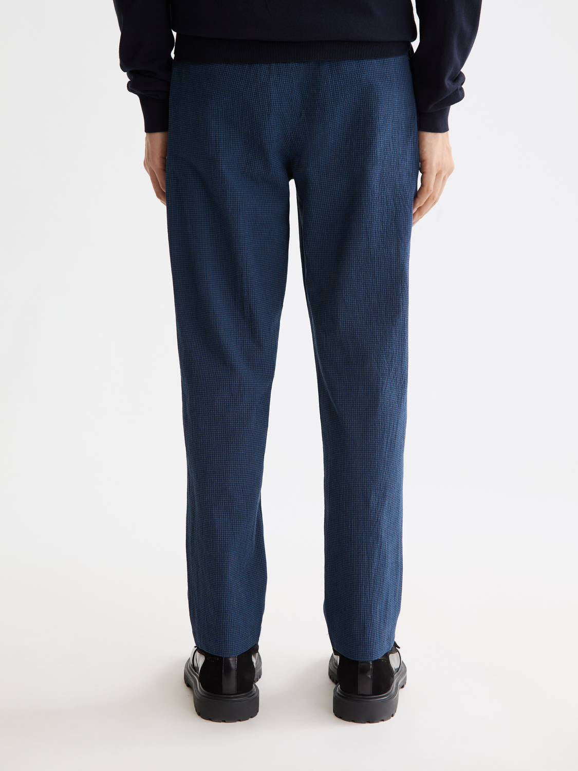 Back view of SCOTCH & SODA Finch tapered-fit pants in dark fabric, featuring tailored fit and clean stitching.