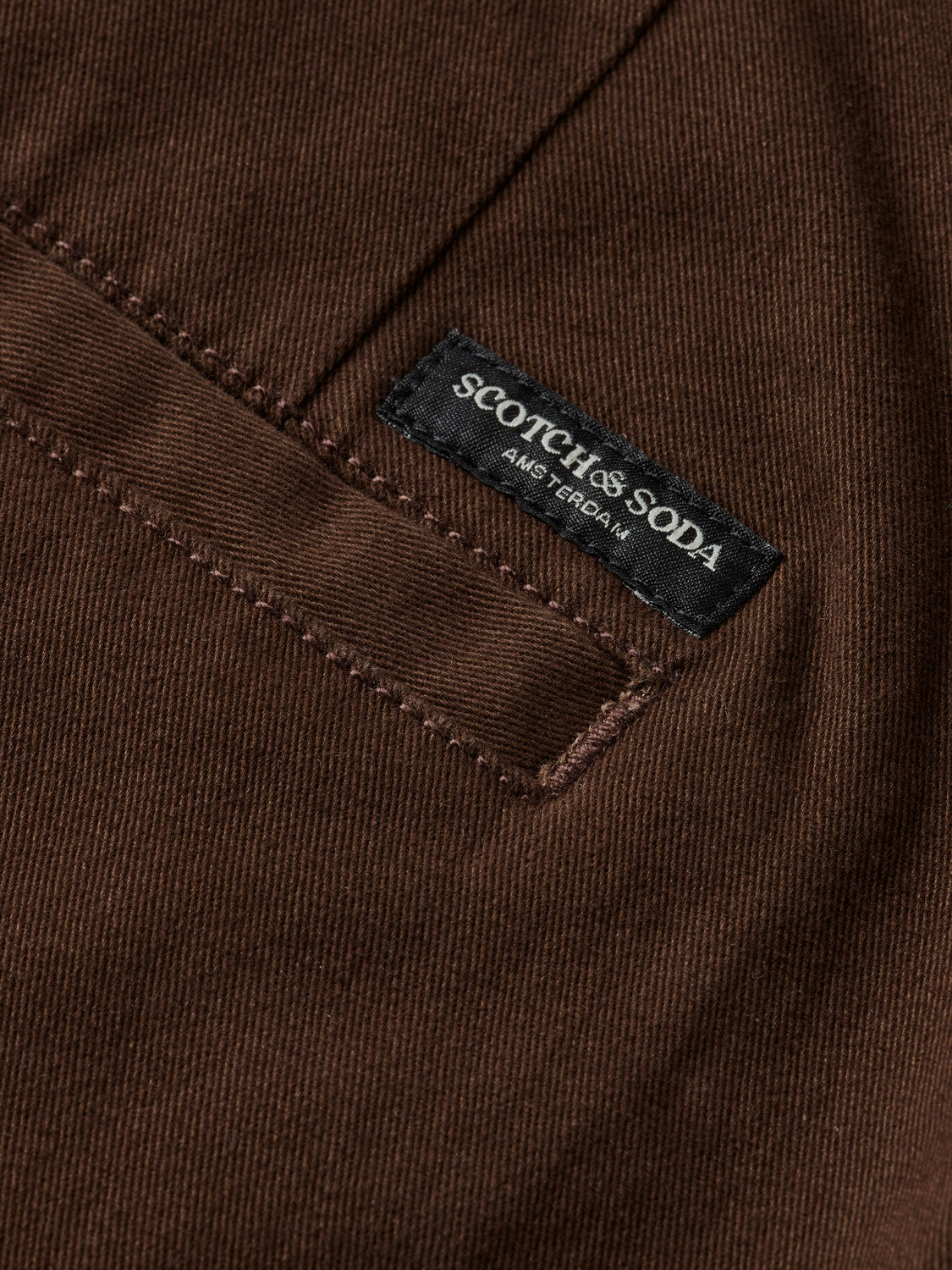 Slim-fit Mott chinos by Scotch & Soda, showing the tan pants with front pockets and belt loops on a plain background.