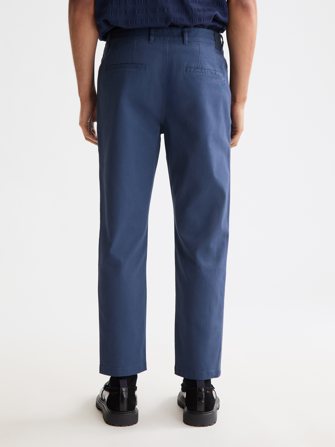 SCOTCH & SODA Drift tapered chinos pants in a dark color, showing the back view with a tailored fit and subtle stitching details.