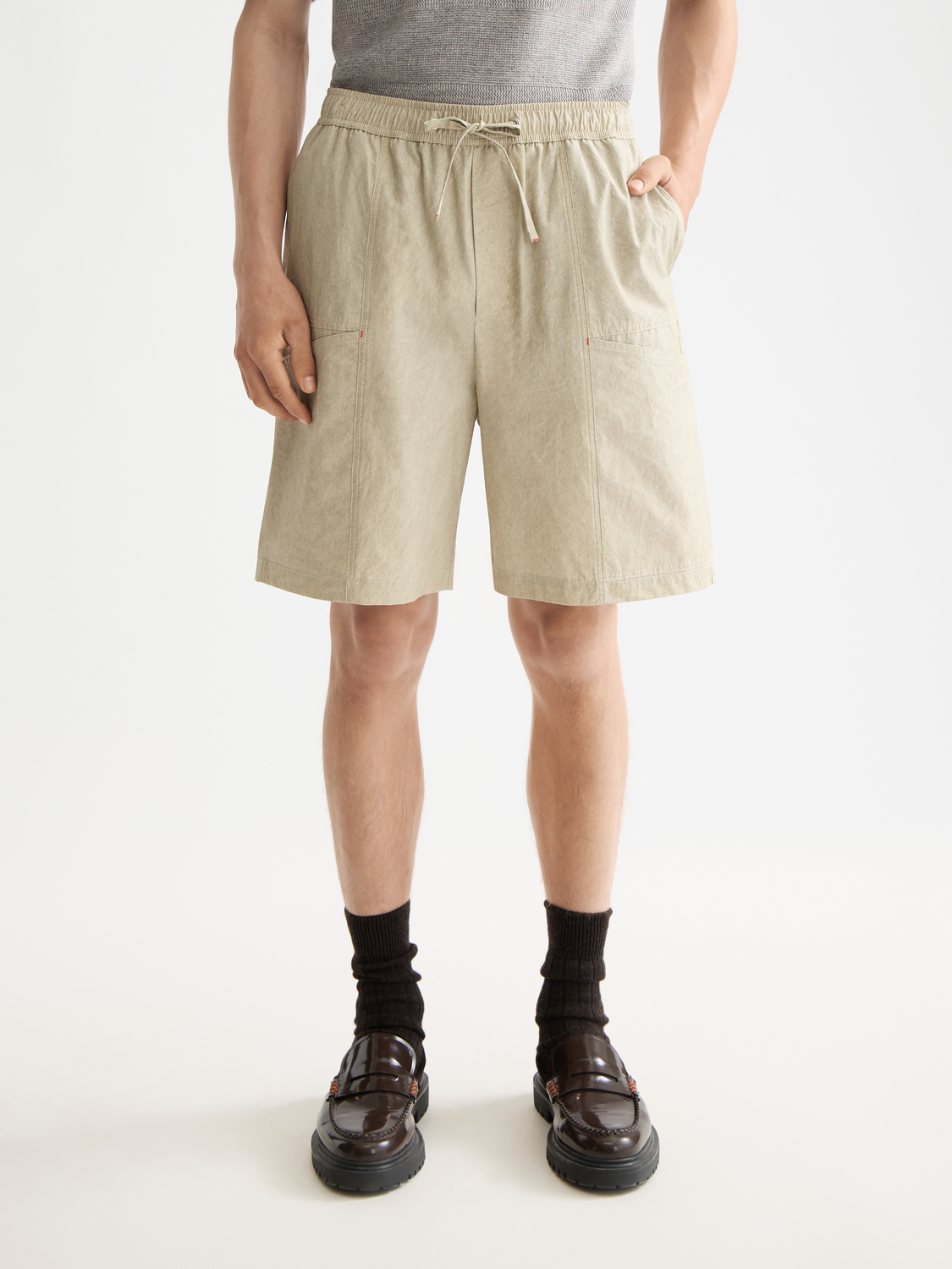 SCOTCH & SODA cargo shorts with multiple pockets, beige color, and relaxed fit, displayed on a hanger against a plain background.