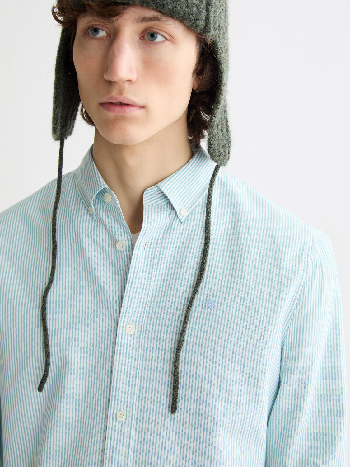 Long-sleeve striped Oxford shirt by Scotch & Soda displayed on a hanger, featuring classic blue and white vertical stripes.
