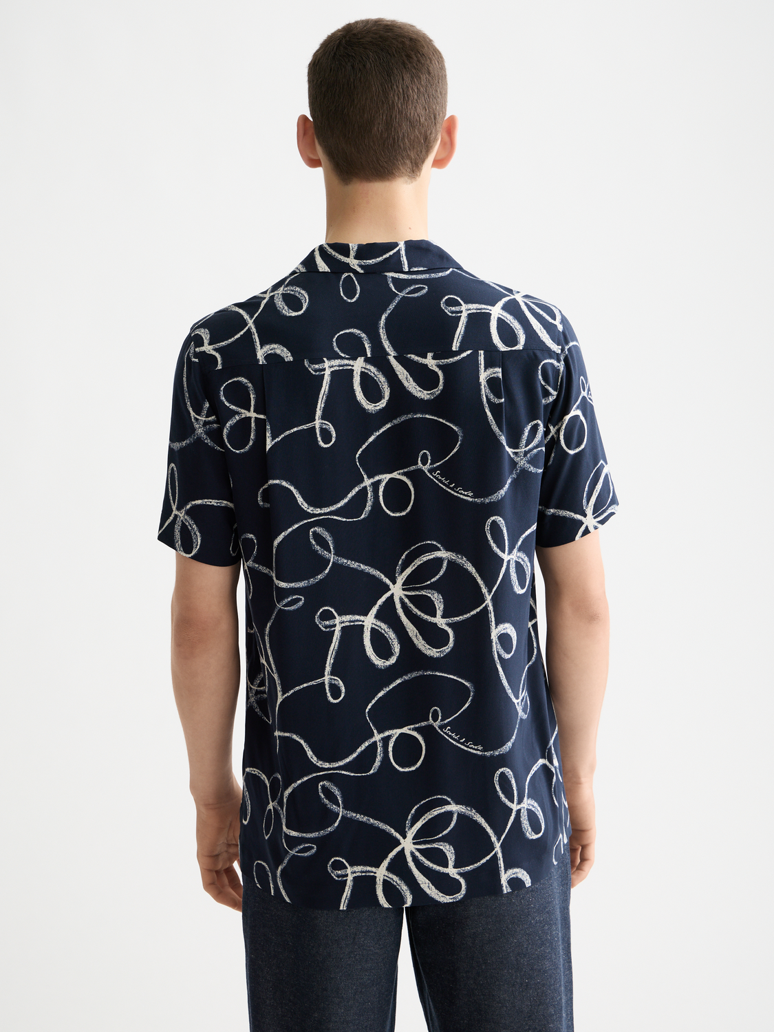 Printed Scotch & Soda short-sleeved shirt with colorful pattern, button-up front, and classic collar on a plain background.