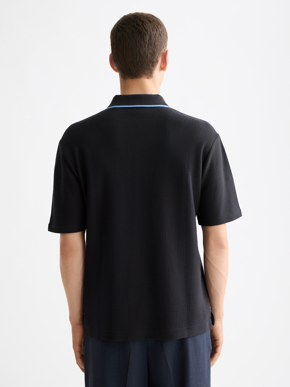 Structured black polo shirt from Scotch & Soda with a classic collar and short sleeves, displayed on a plain background.