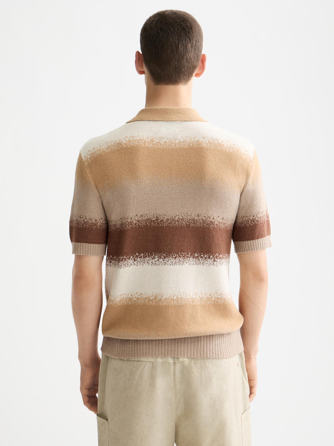 Knitted gradient polo shirt by Scotch & Soda featuring a color fade, classic collar, and short sleeves on a plain background.