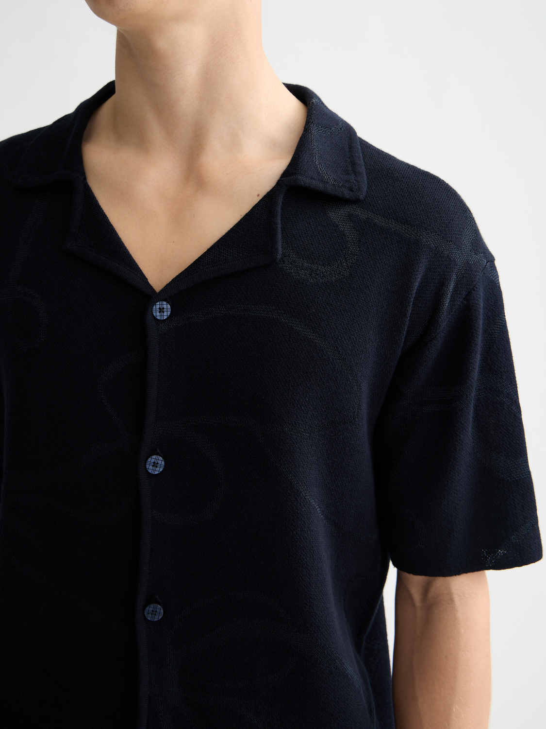 Scotch & Soda jacquard short-sleeved knitwear shirt with intricate pattern and textured fabric, displayed on a plain background.