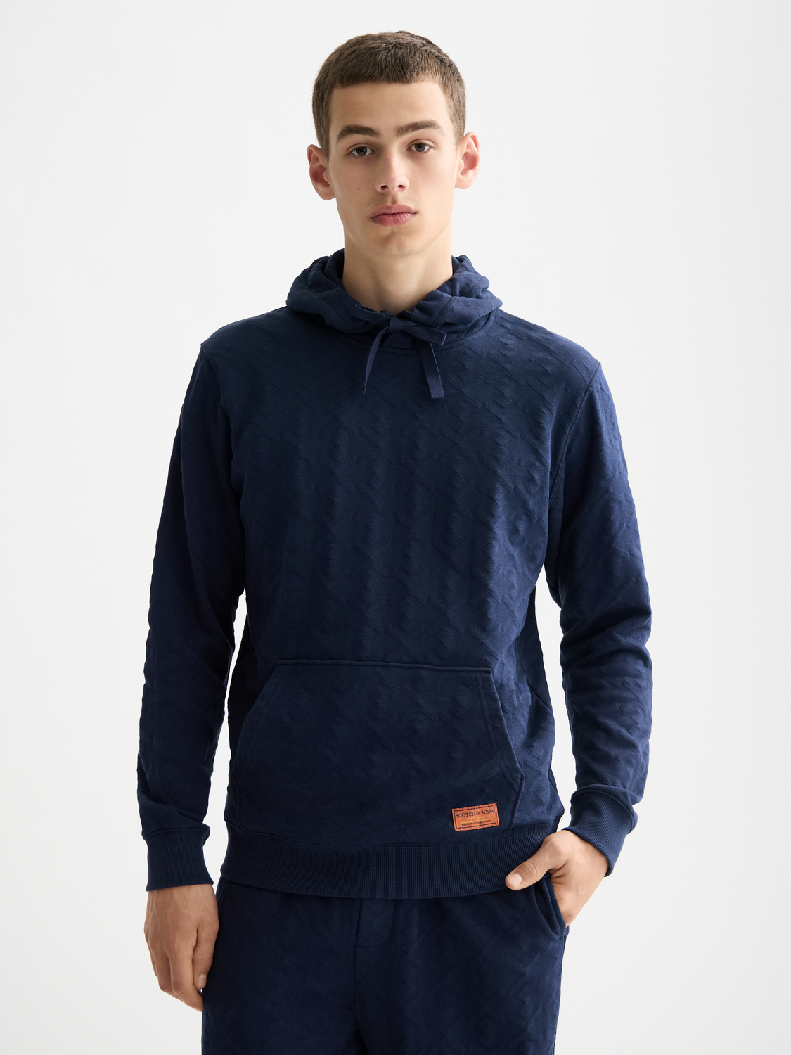 Scotch & Soda jacquard terry hoodie in gray with a relaxed fit and hood, front pocket, and ribbed cuffs.