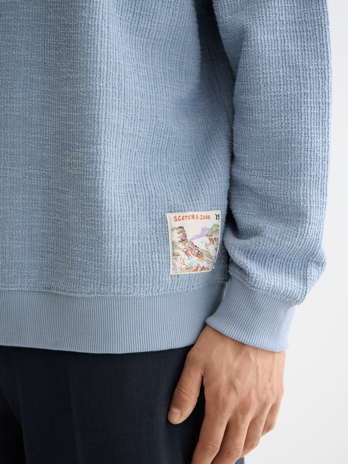 Textured SCOTCH & SODA sweatshirt with long sleeves and ribbed cuffs, shown on a plain background.