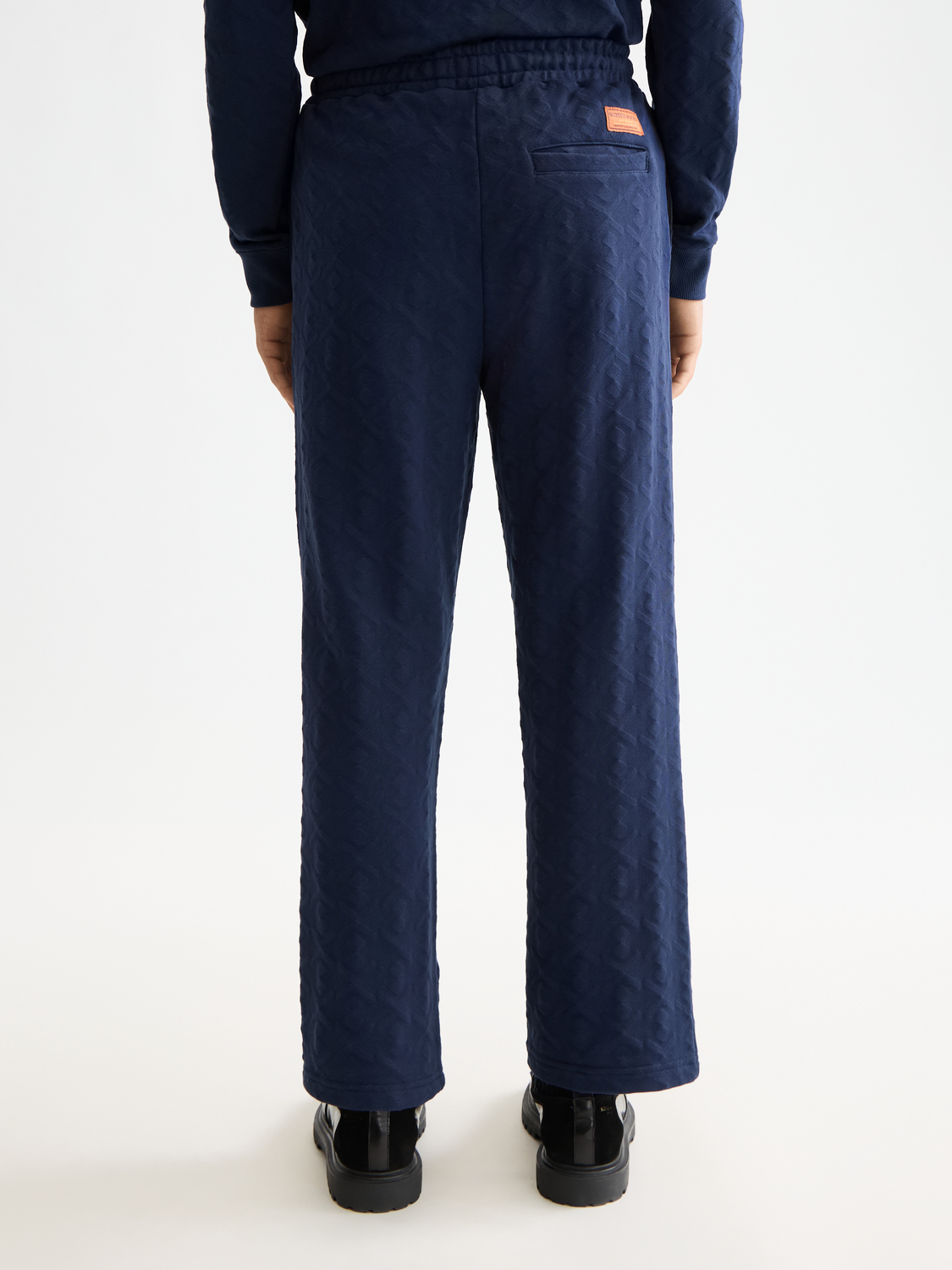 Scotch & Soda jacquard terry sweatpants with a relaxed fit, shown from the back with a detailed textured pattern.