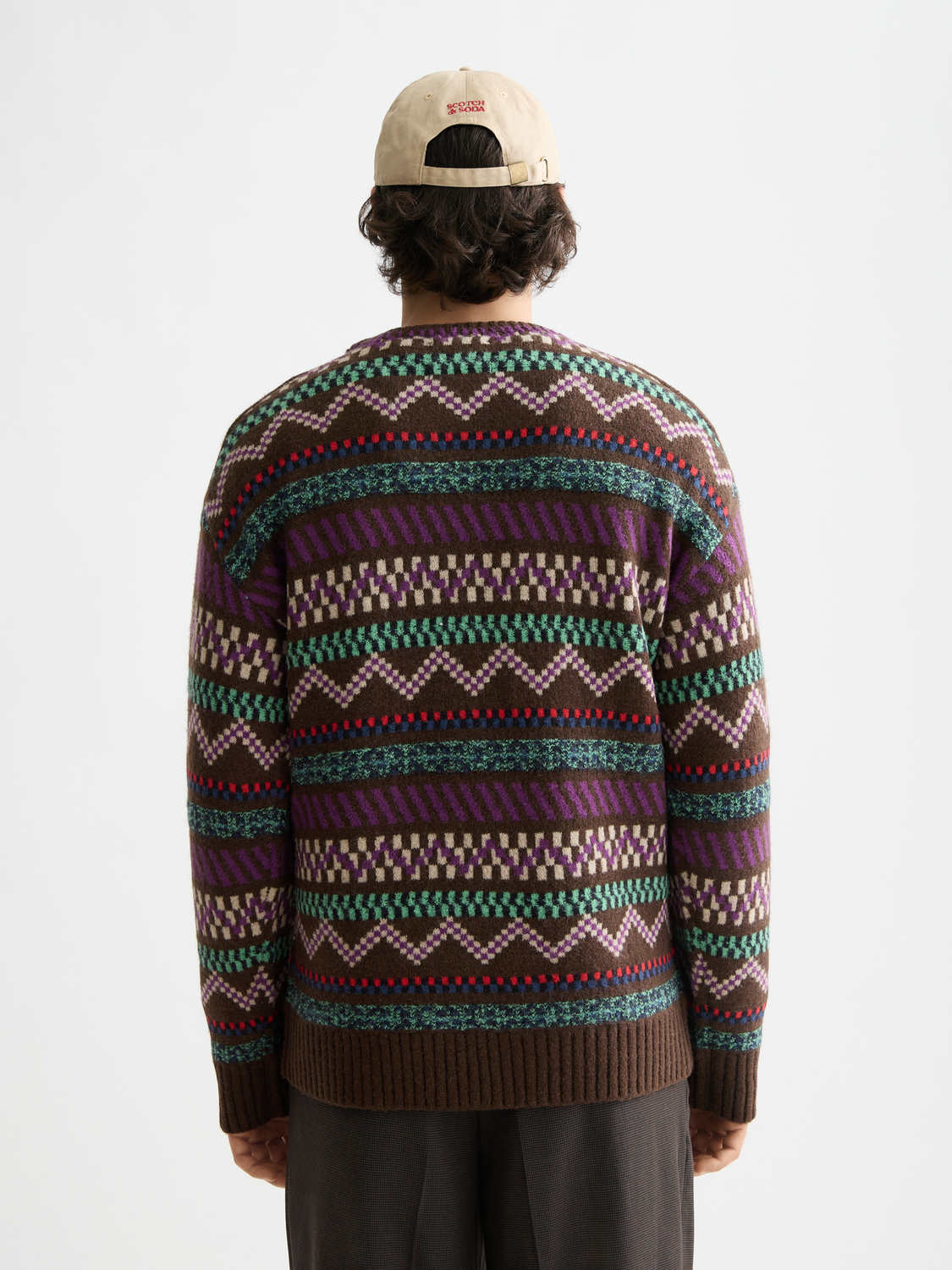 Jacquard knitted Scotch & Soda pullover in black with intricate patterns, displayed on a hanger against a plain background.