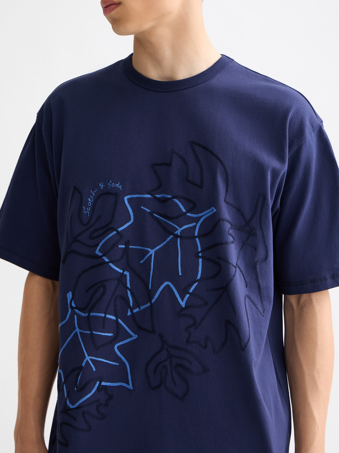 Embroidered SCOTCH & SODA short-sleeve t-shirt with colorful floral design on light fabric, casual and stylish.
