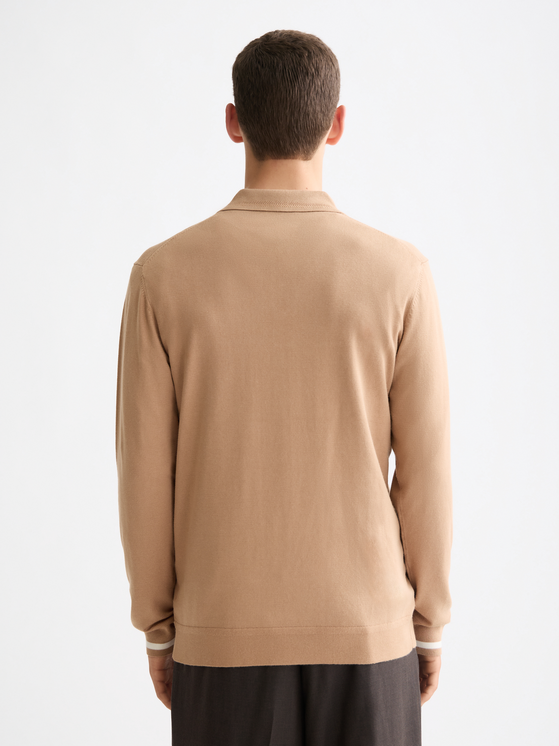 Knitted long-sleeved polo shirt from Scotch & Soda, featuring a classic collar and textured knit fabric, shown from the back.