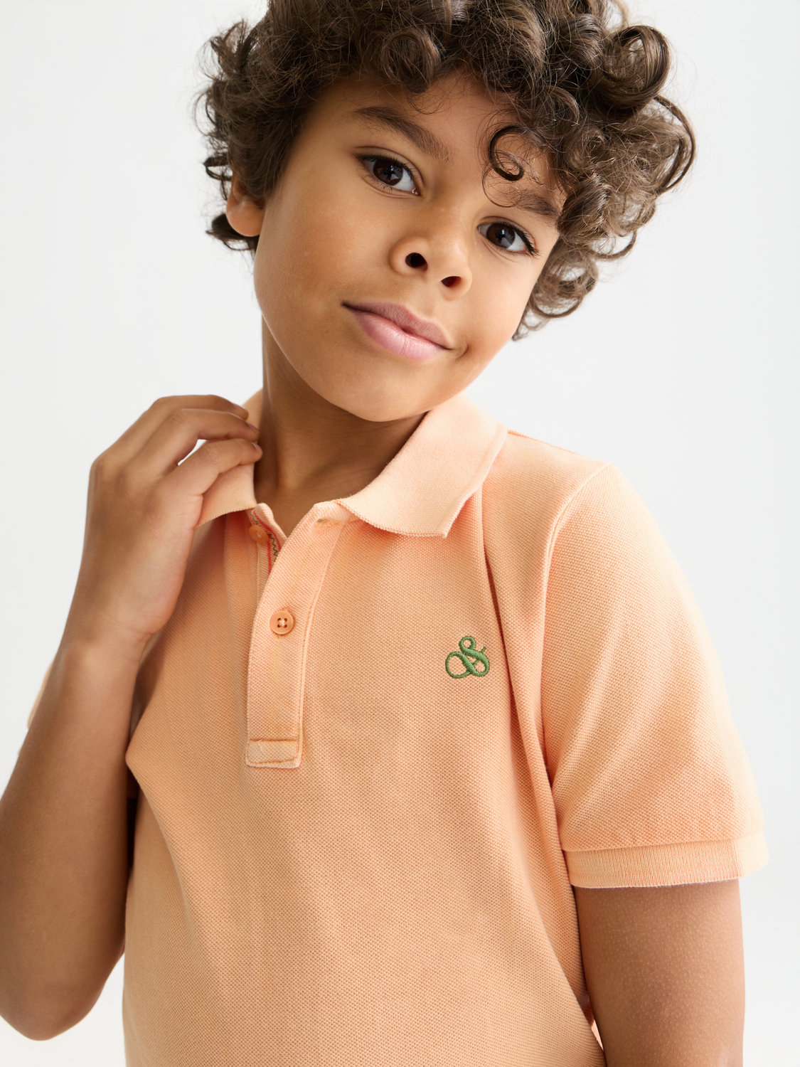 Kids' garment-dyed pique polo shirt by Scotch & Soda, featuring a classic collar and short sleeves in vibrant colors.