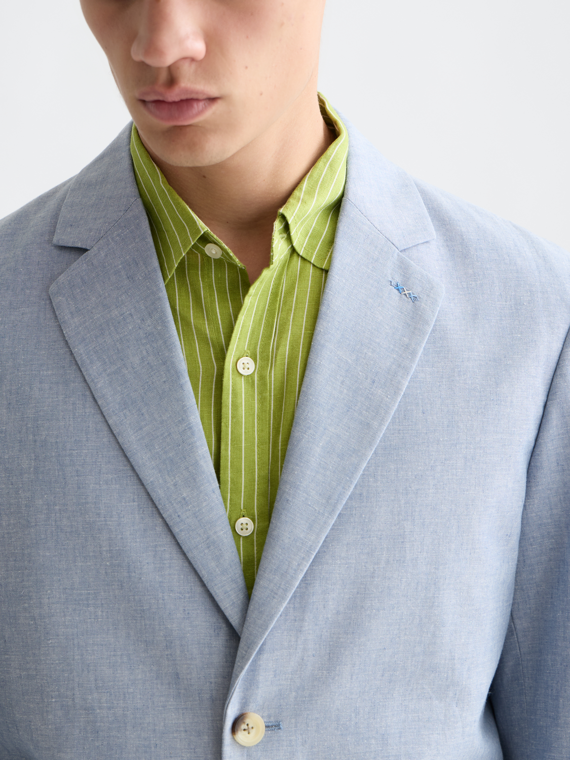 Unconstructed SCOTCH & SODA blazer with a tailored fit, shown on a hanger, in a neutral color with a classic lapel design.