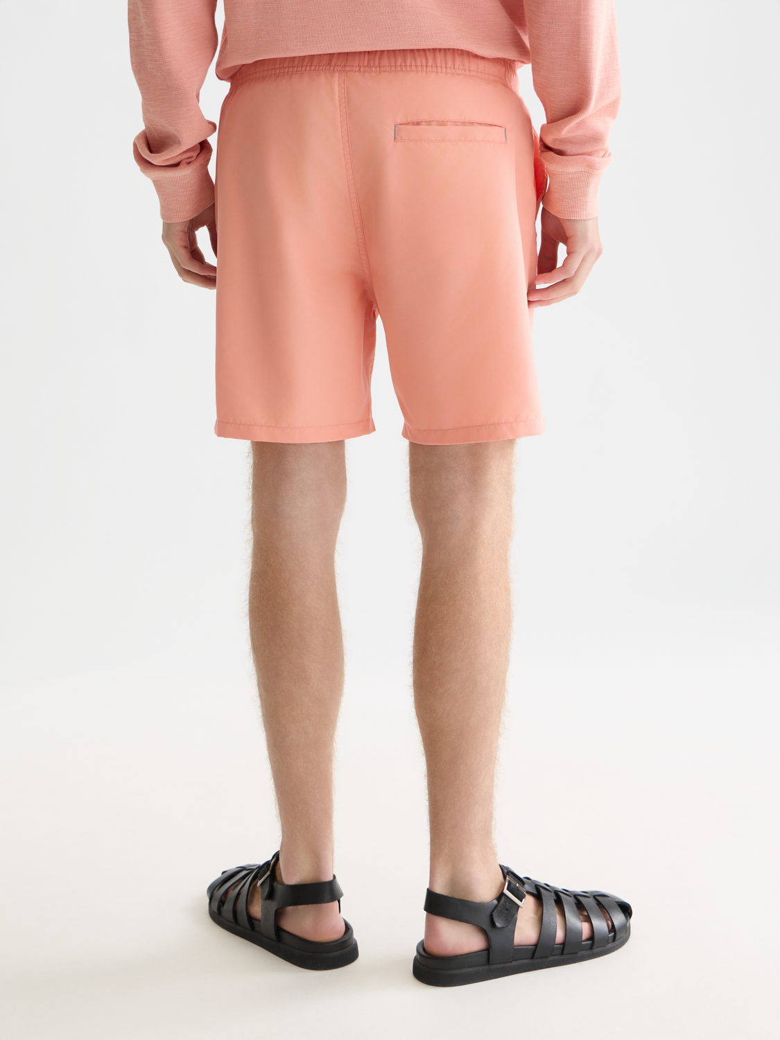Mid-length Scotch & Soda swim shorts in vibrant coral color, displayed from the back with a drawstring waistband and side pockets.