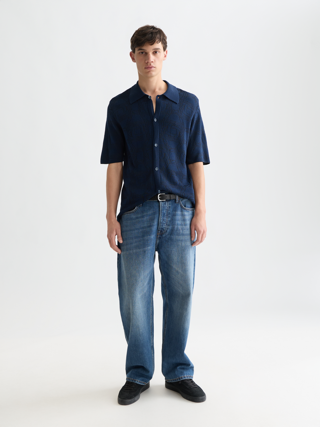 Knitted jacquard short-sleeved shirt by Scotch & Soda, showing intricate pattern, crew neck, and soft knit fabric.