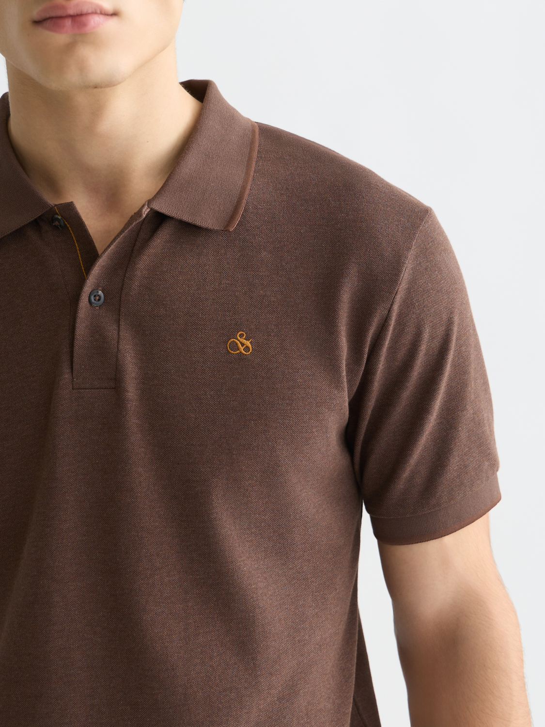 Scotch & Soda Melange Polo shirt in muted tones, featuring a classic collar and short sleeves, laid flat on a neutral background.