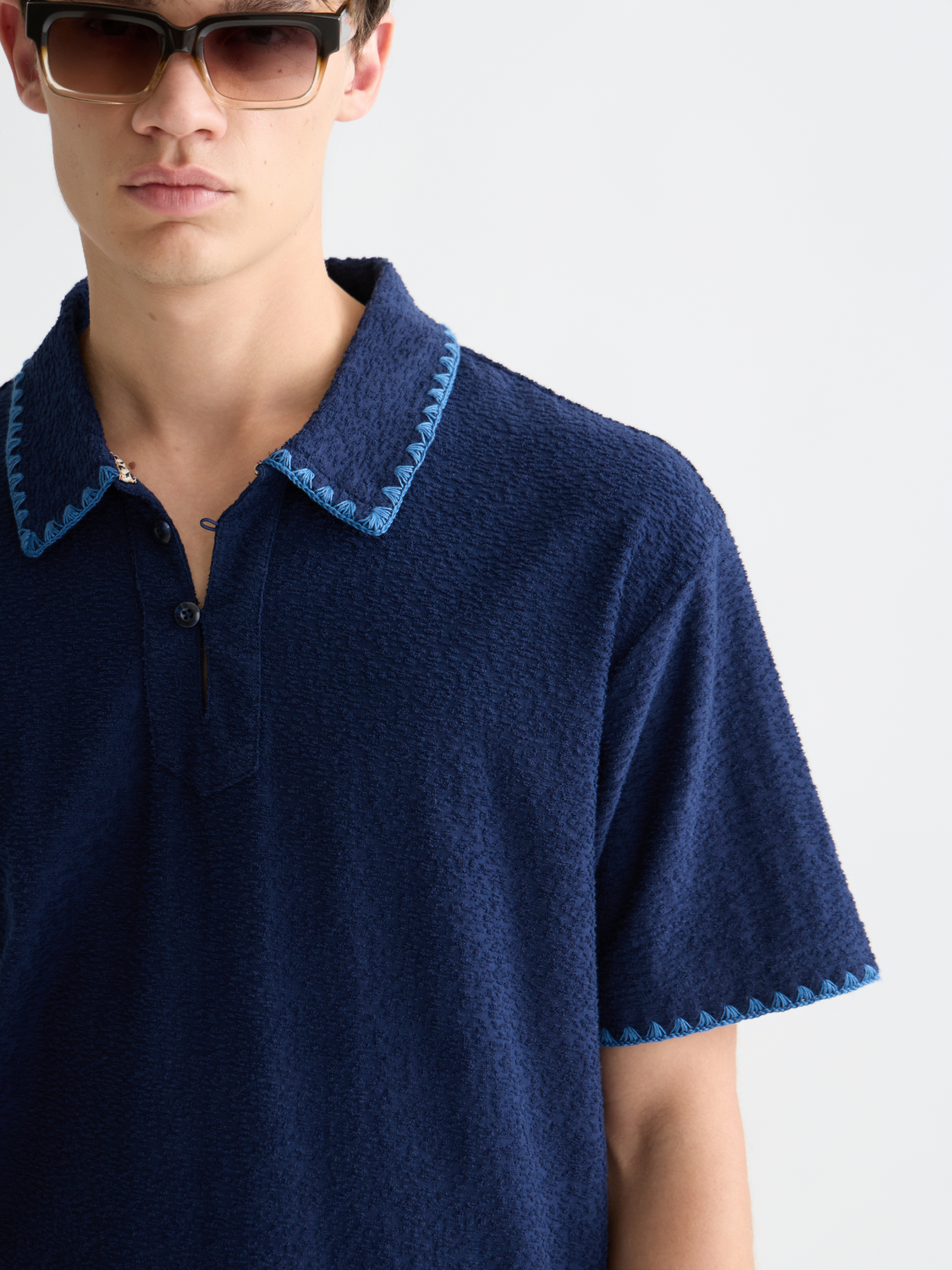 Scotch & Soda jacquard towelling polo shirt in navy with textured pattern and classic collar, displayed on a model.