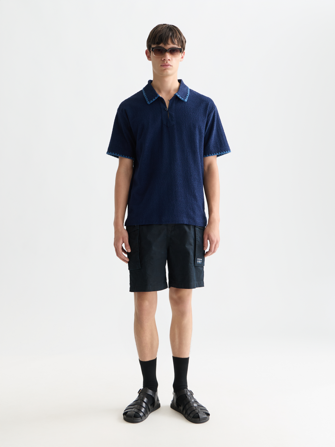 SCOTCH & SODA Jacquard towelling polo shirt in navy with textured fabric and classic collar, front view.