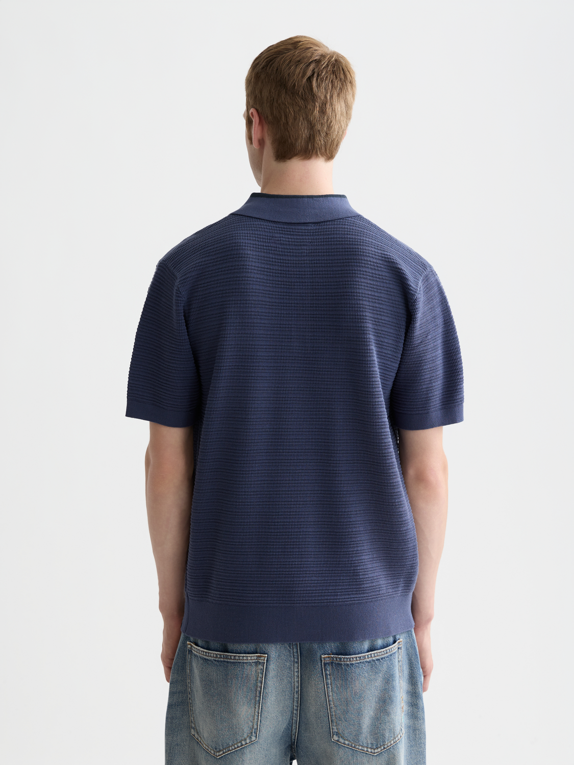 Structured navy knit polo shirt by Scotch & Soda featuring a classic collar and textured knit fabric.