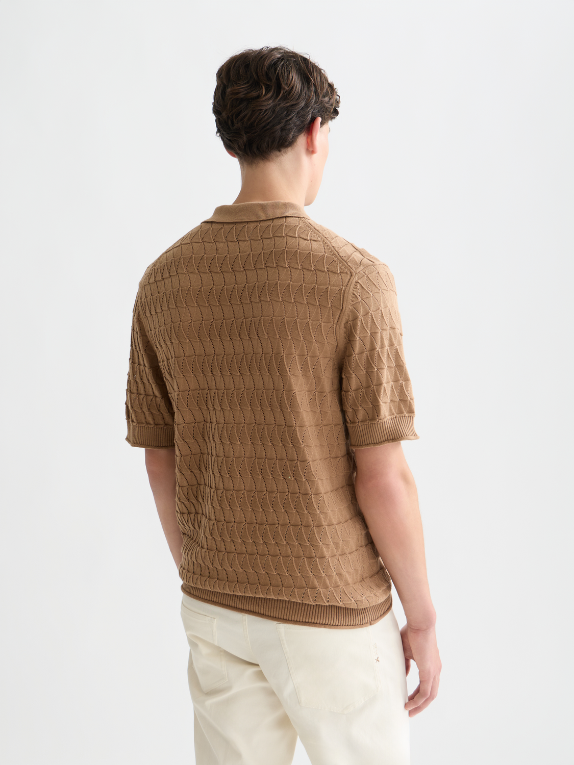 Knitted polo shirt by Scotch & Soda, featuring a close-up of the back with textured knit fabric and classic collar detail.
