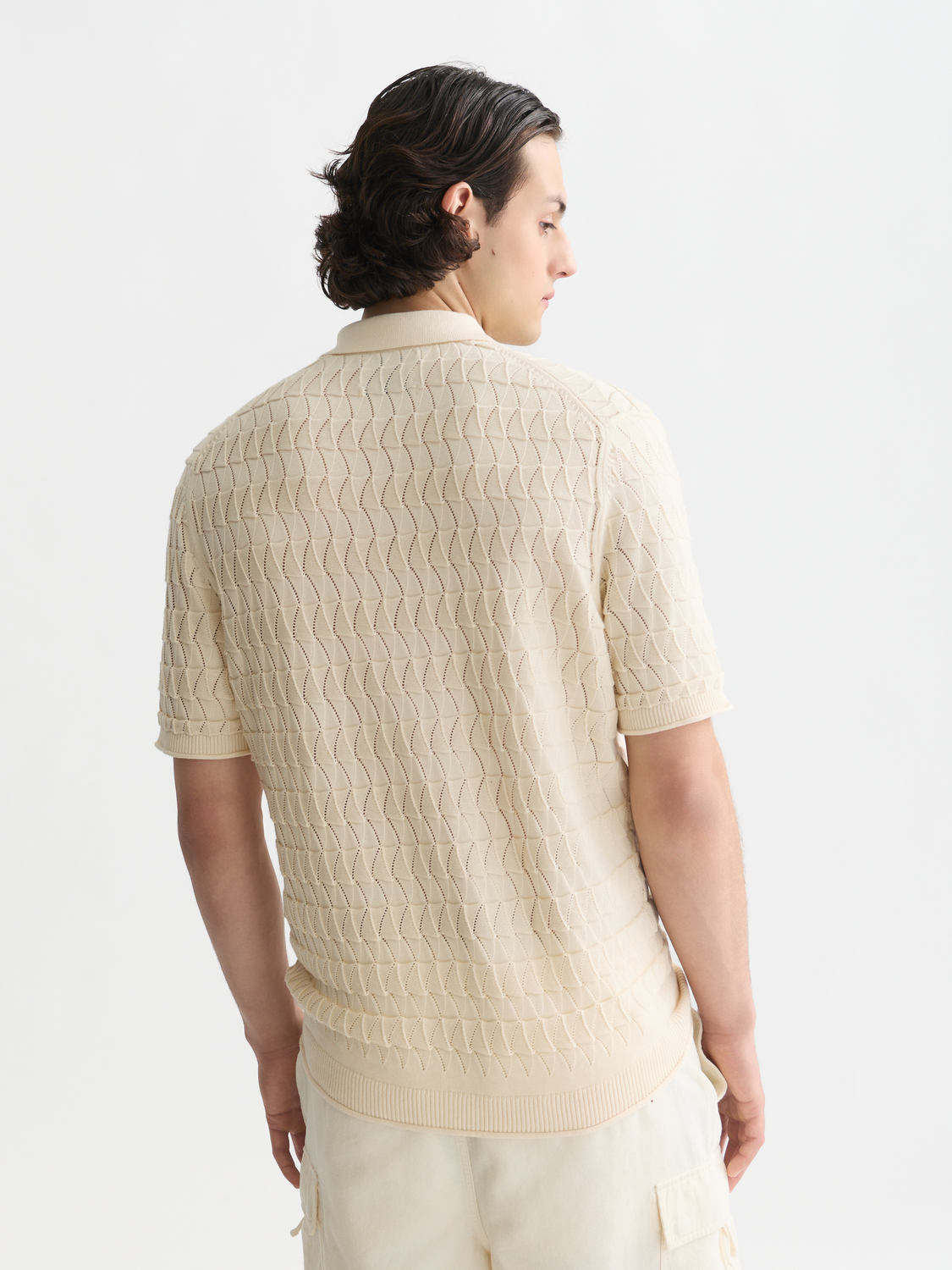 Knitted SCOTCH & SODA polo shirt in cream color, featuring a classic collar and textured knit fabric.