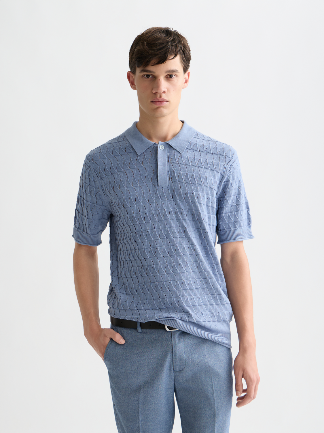 Close-up of a blue knitted polo shirt by Scotch & Soda, featuring a classic collar and textured knit fabric.
