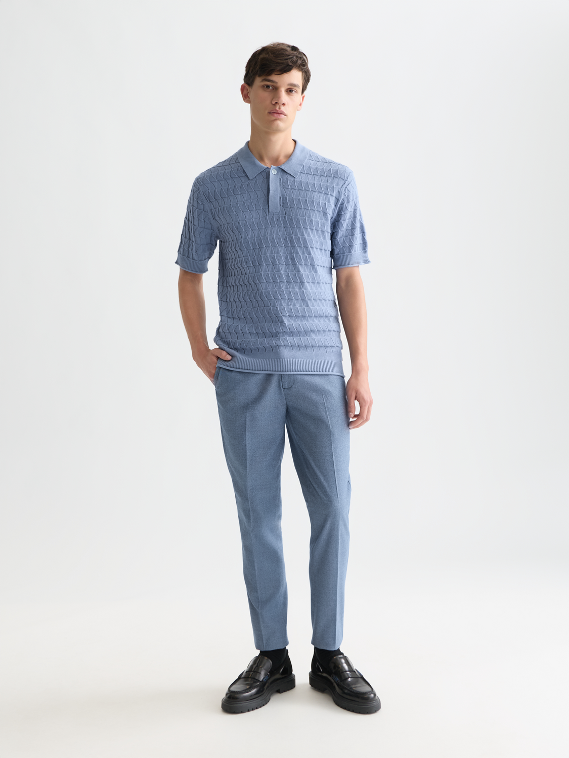 Light blue knitted polo shirt from Scotch & Soda, showing the front view with a classic collar and textured knit fabric.