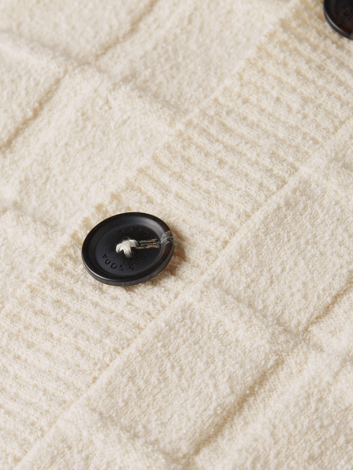 Structured boucle cardigan from SCOTCH & SODA, showing textured knitwear with a tailored fit and button closure.