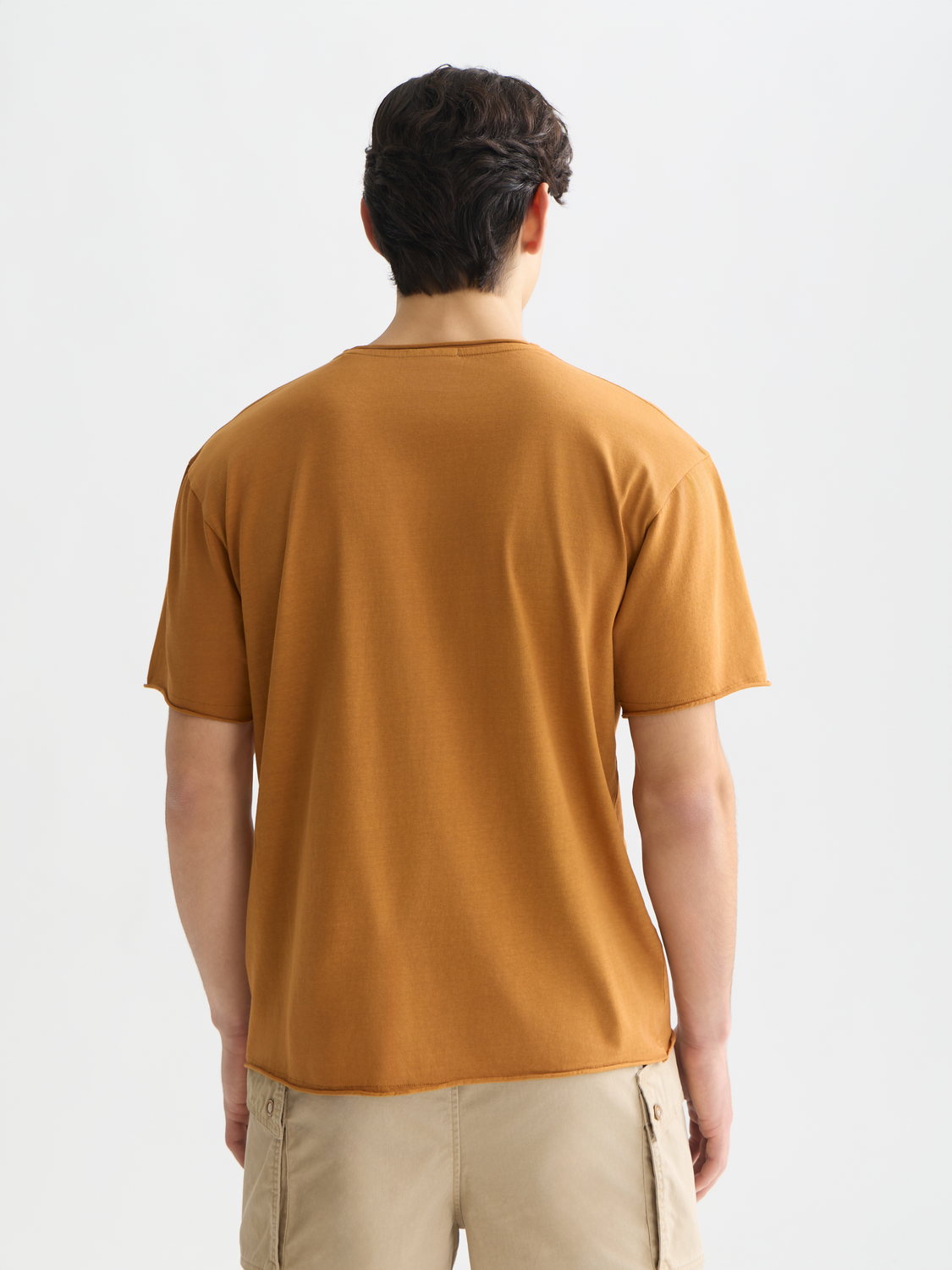 Raw edge short sleeve T-shirt by Scotch & Soda, casual fit with distressed hem and soft cotton fabric, shown from the back.