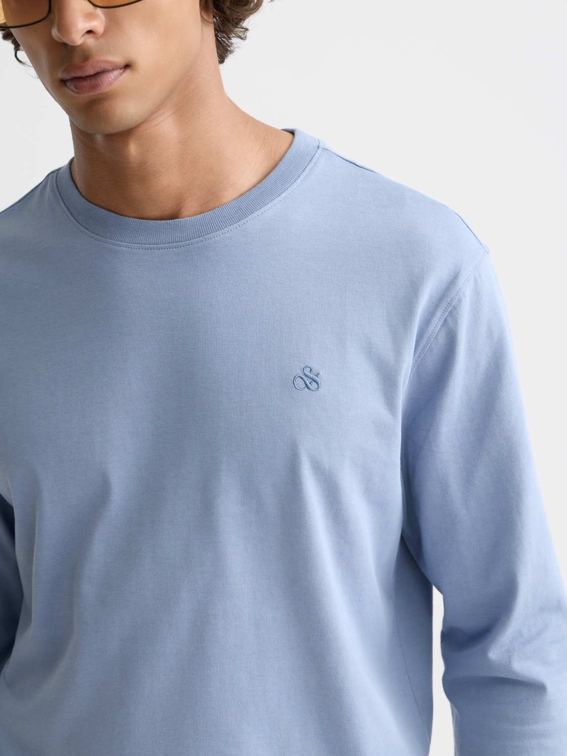 Black long-sleeved T-shirt with Scotch & Soda logo print, casual fit, and ribbed cuffs, displayed on a plain background.