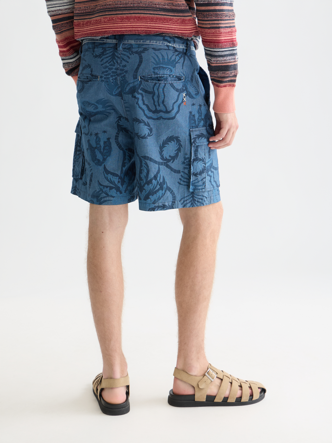 Dark blue printed denim cargo shorts by Scotch & Soda with multiple pockets and rolled hems, shown from the back view.