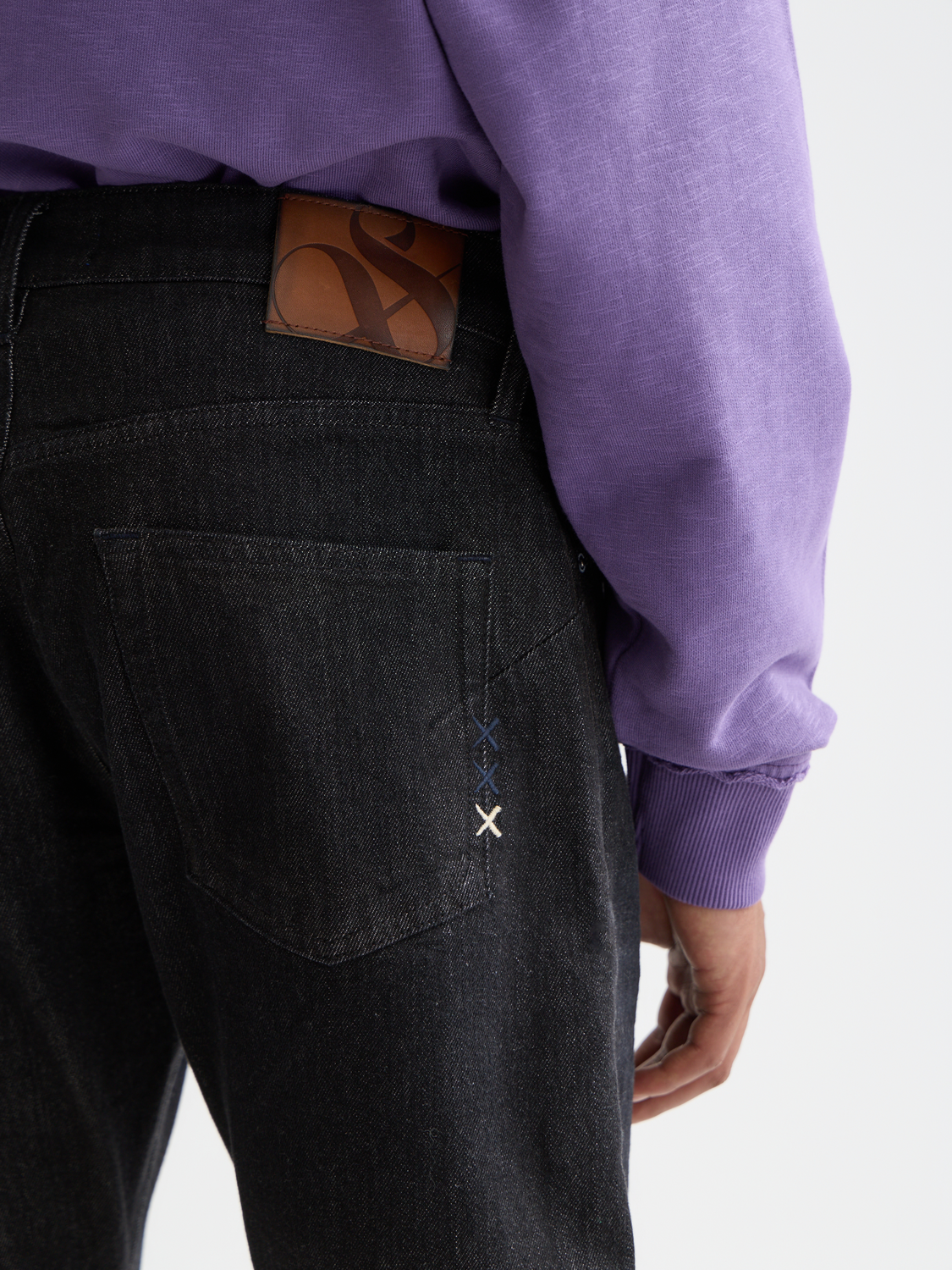 Light blue Scotch & SODA Zee straight-fit Denim jeans displayed on a hanger. Classic five-pocket design and clean stitching.