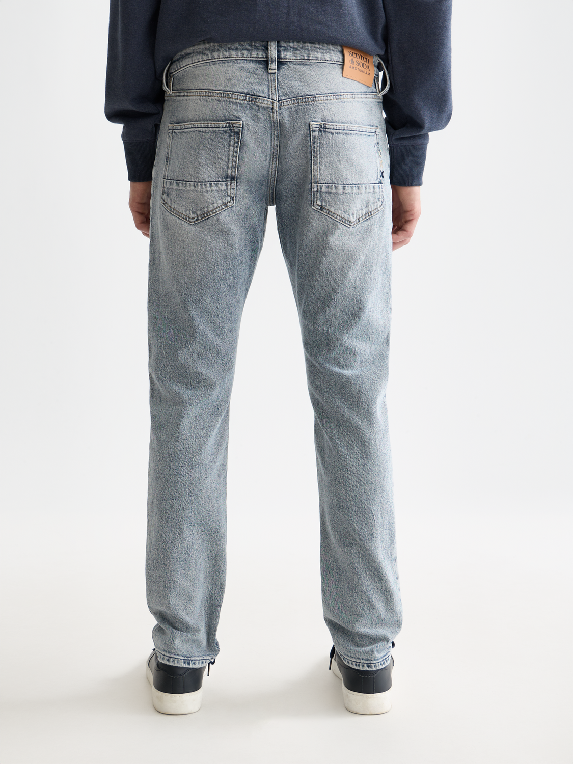 Slim-fit Ralston denim jeans by Scotch & Soda, showing back view with classic blue fabric and subtle stitching details.