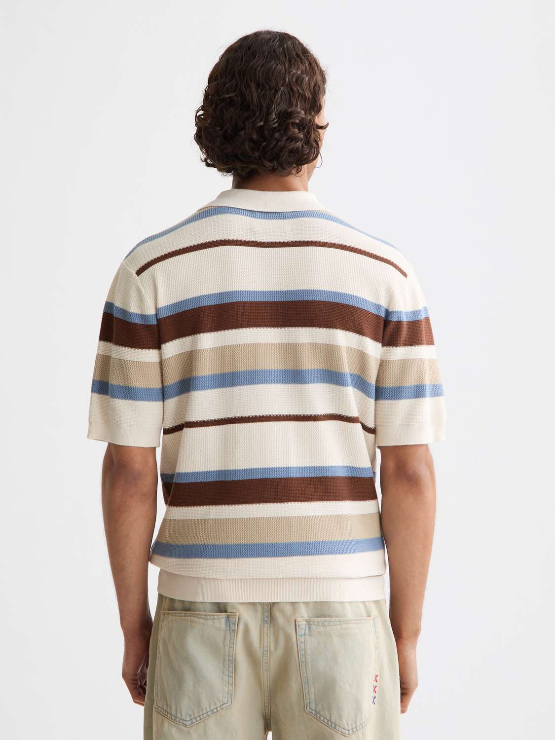 Knitted striped polo shirt by Scotch & Soda, featuring a classic fit and multicolor stripes, shown from the back.