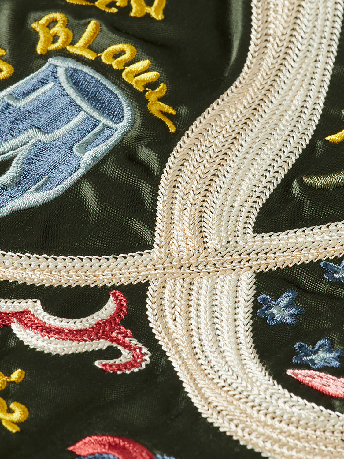Reversible souvenir bomber jacket by Scotch & Soda featuring bold patterns and vibrant colors, displayed on a hanger.