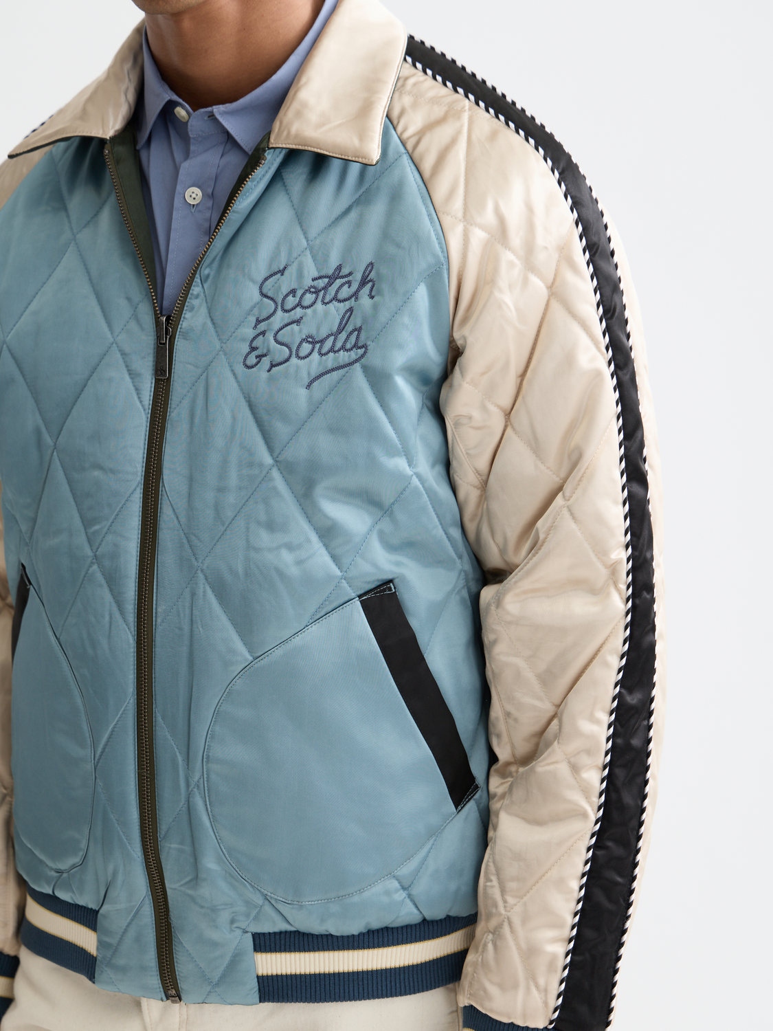Reversible souvenir bomber jacket by Scotch & Soda featuring colorful patterns and casual fit, displayed on a hanger.