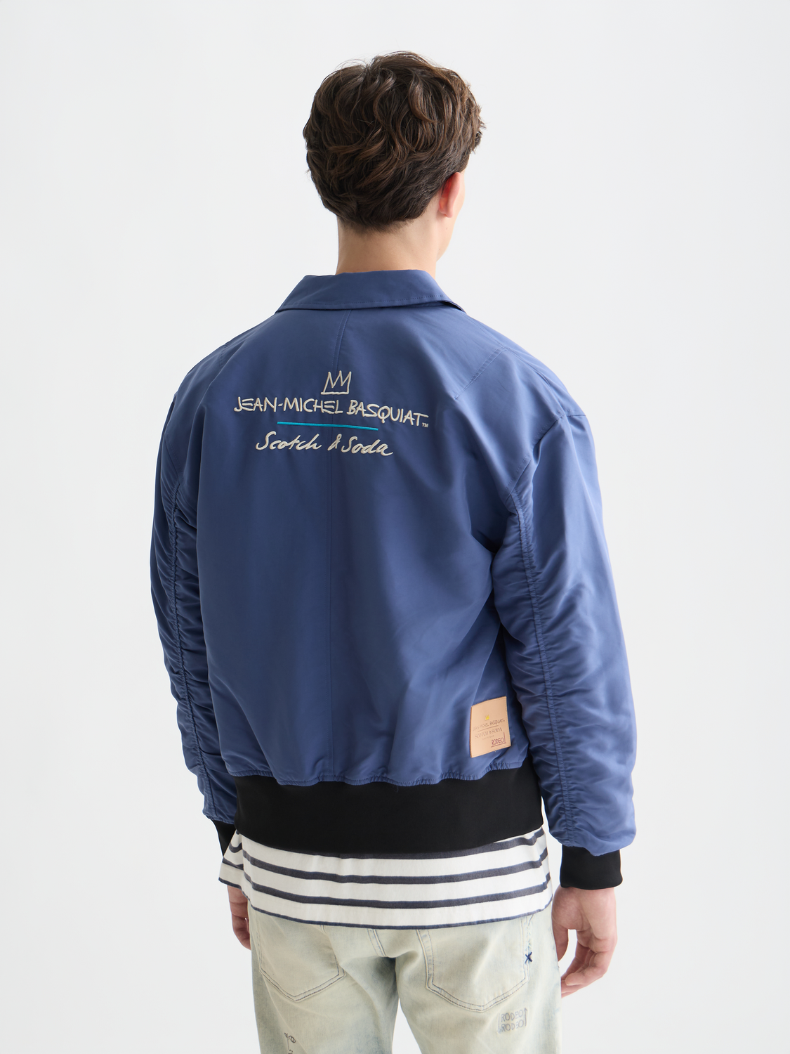 SCOTCH & SODA S&S x Basquiat souvenir jacket with vibrant artwork, front and back views showing detailed design and bold colors.