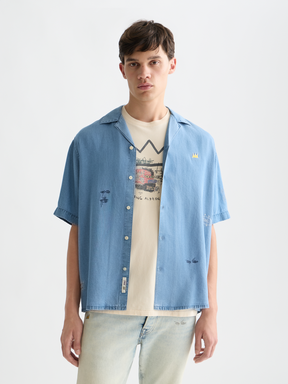 Blue short-sleeved shirt by Scotch & Soda featuring Basquiat-inspired artwork, casual fit, and indigo fabric.