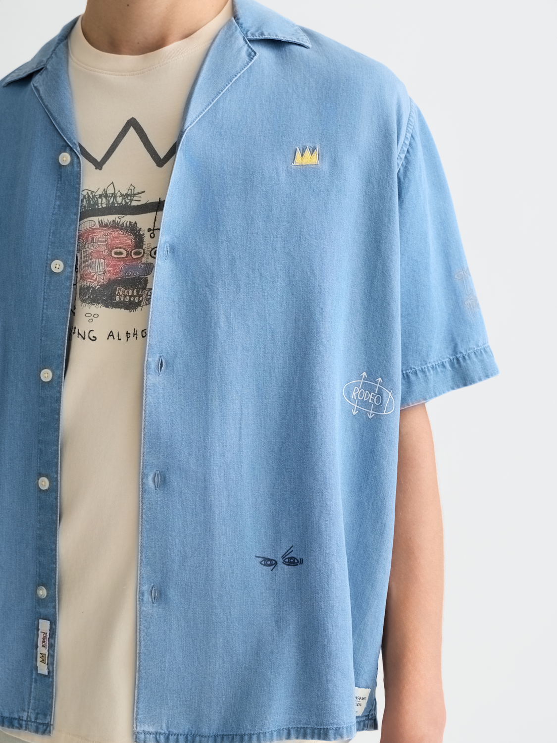 Indigo short-sleeved shirt by Scotch & Soda featuring Basquiat artwork design, casual style, and relaxed fit.