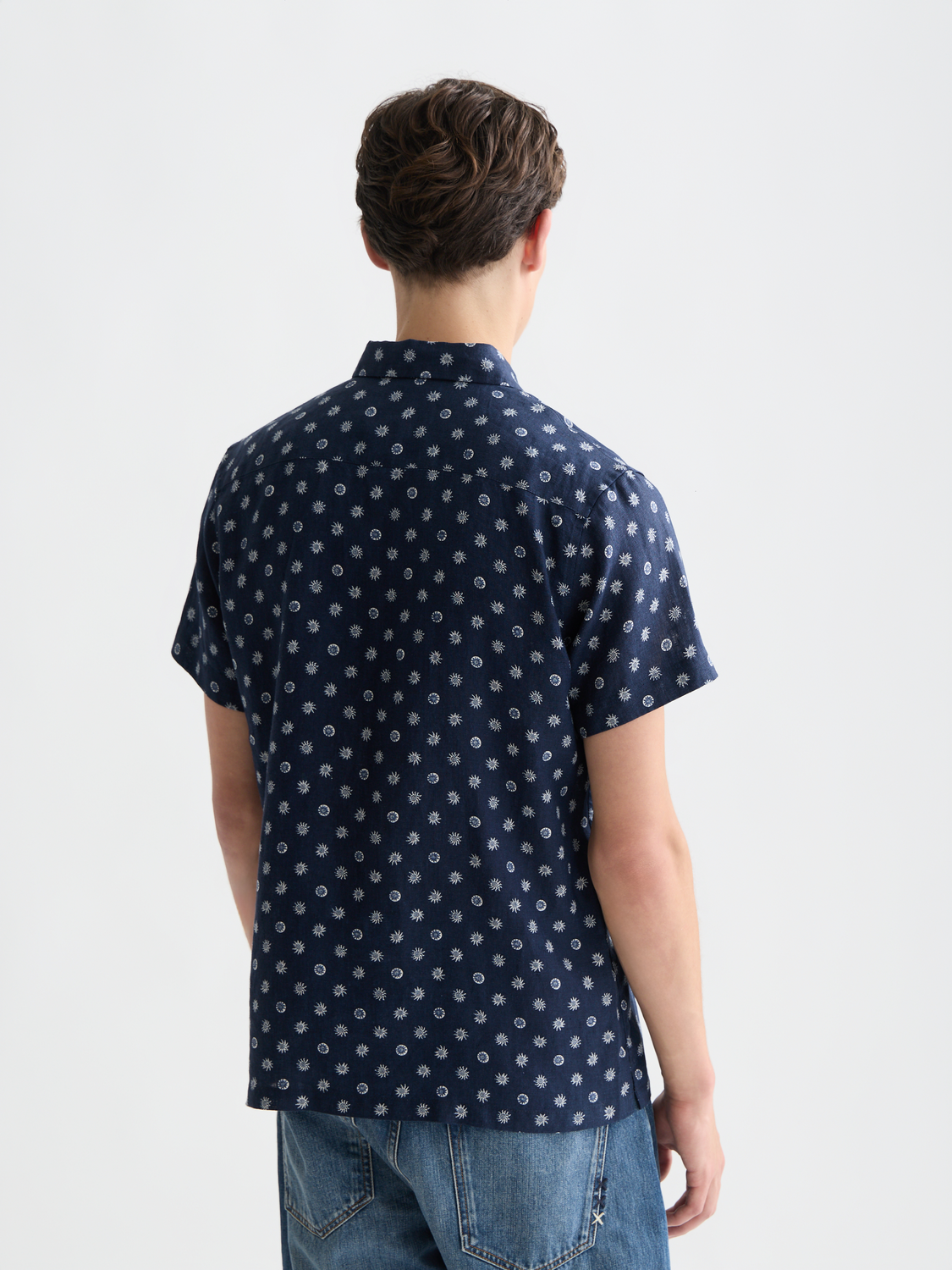 Printed short-sleeved linen shirt by Scotch & Soda, lightweight fabric with a vibrant pattern, shown from the back.