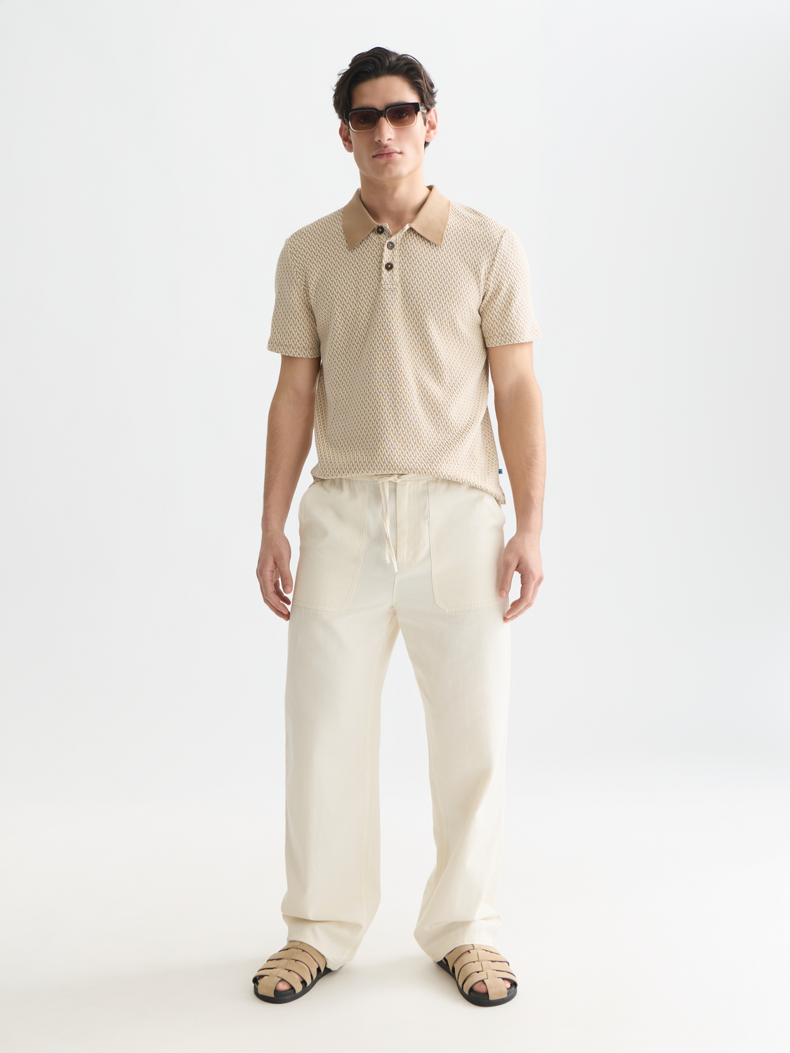 Scotch & Soda jacquard polo shirt with intricate woven pattern, classic collar, and short sleeves on a neutral background.