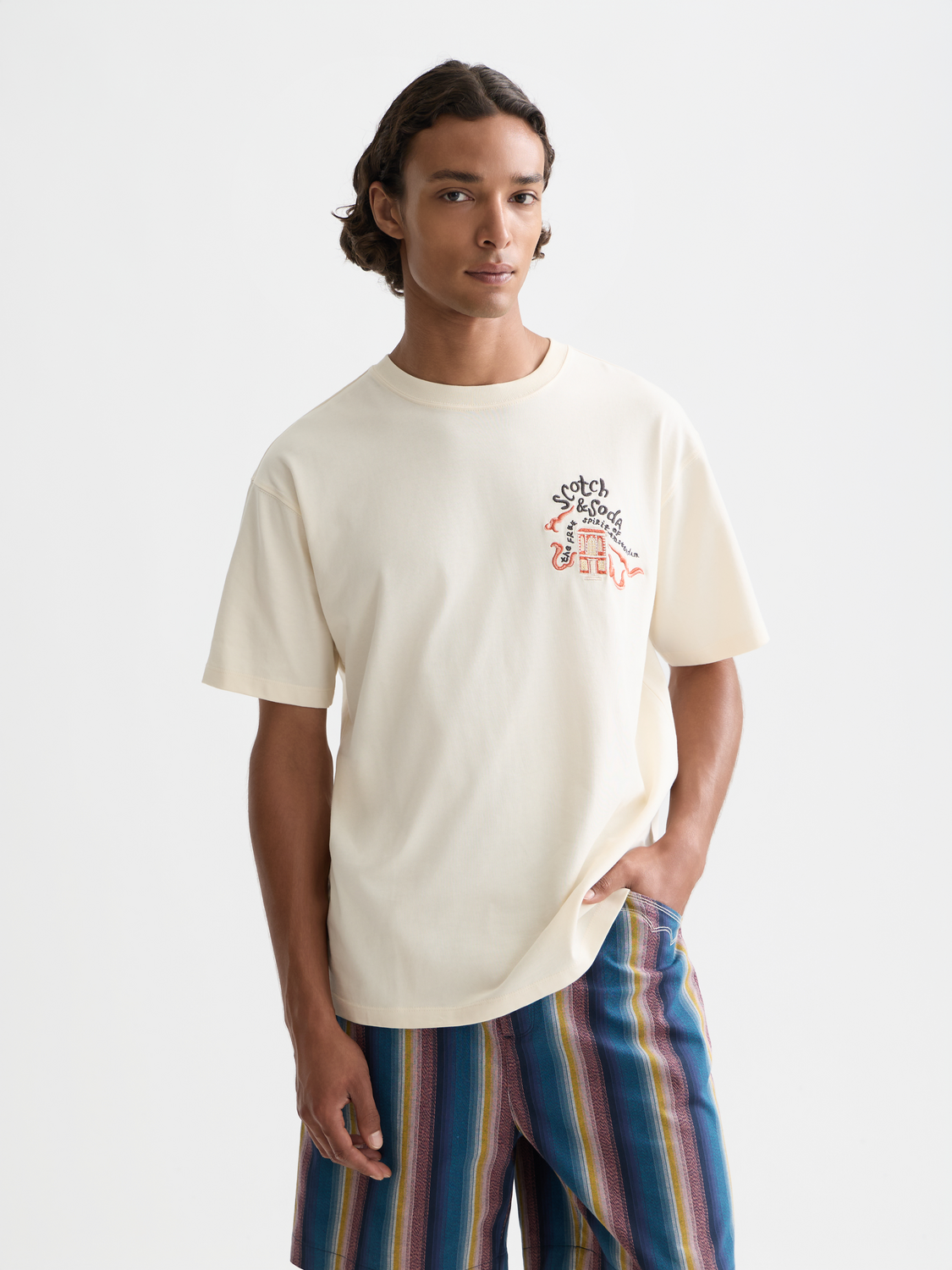 White embroidered Scotch & Soda short-sleeve t-shirt with colorful floral design on front, casual and stylish.