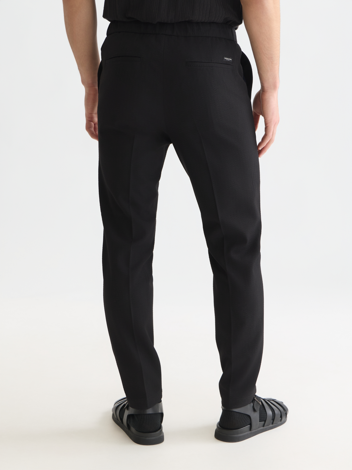 Dark green Scotch & Soda Finch tapered-fit pants shown from the back, featuring a sleek design and tailored fit.