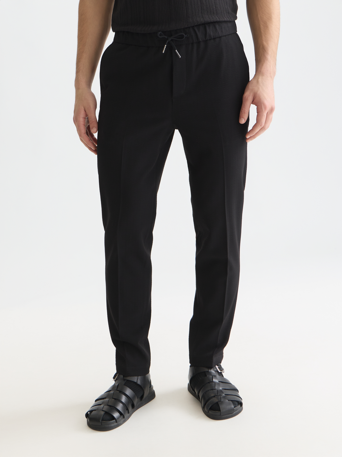 SCOTCH & SODA Finch tapered-fit pants in dark gray fabric, showing the slim fit design and front pockets.